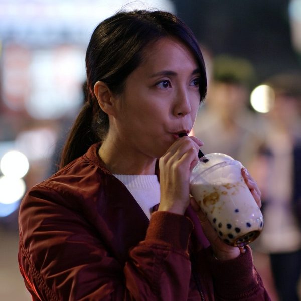 Woman drink of Taiwan iced bubble tea in the night market