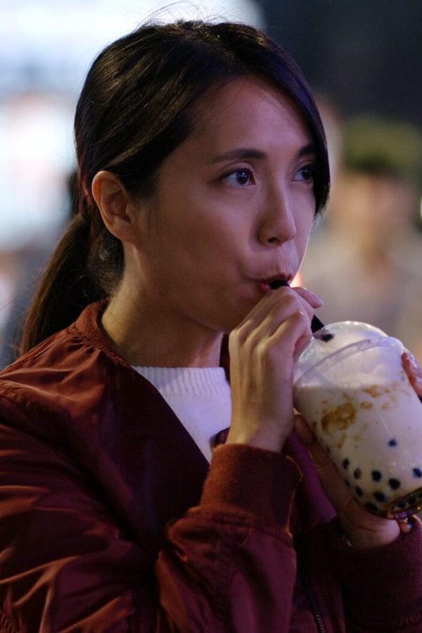 Woman drink of Taiwan iced bubble tea in the night market